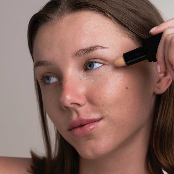 modelo usando Corrector claro/beige suave (Natural y Vegano)